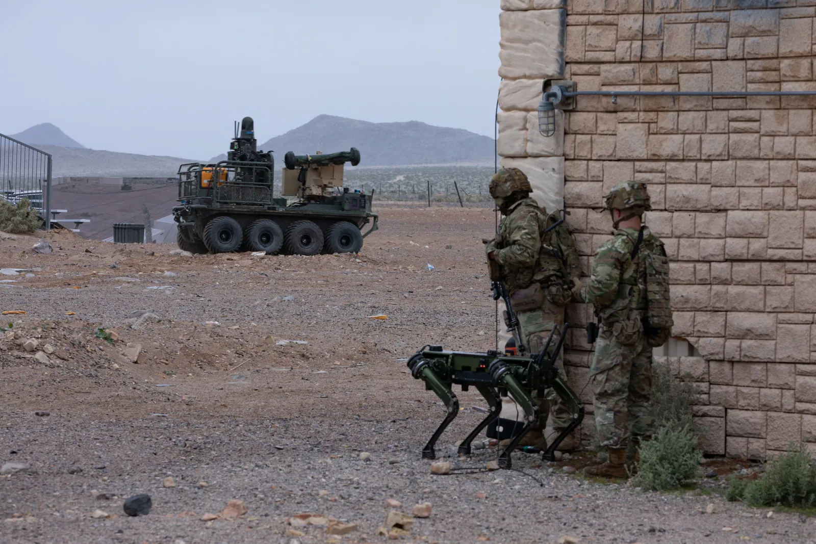 U.S. Air Force soldier kneels next to a robotic dog in front of a military plane